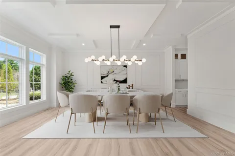 a dining room with furniture a large window and wooden floor