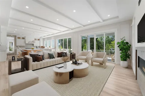 a living room with furniture kitchen view and large windows