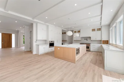 a large kitchen with stainless steel appliances lot of white cabinets