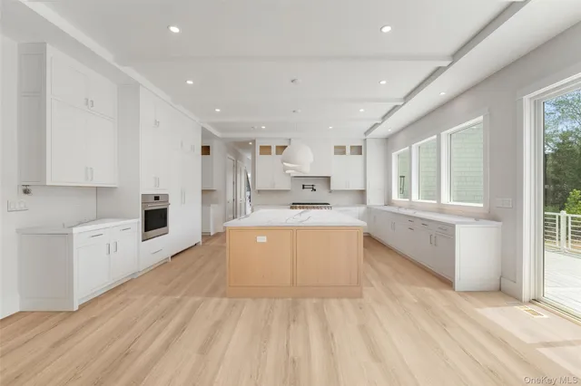 a large white kitchen with cabinets and wooden floor