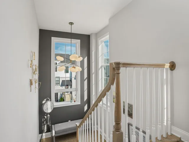 a view of a hallway with wooden floor and stairs