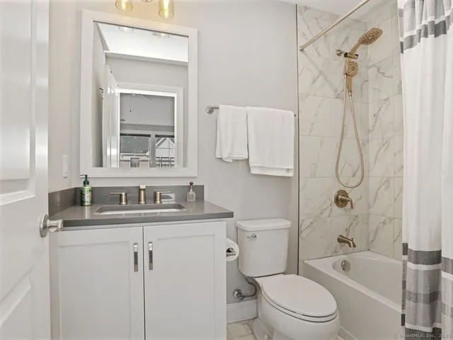 a bathroom with a sink toilet vanity and shower