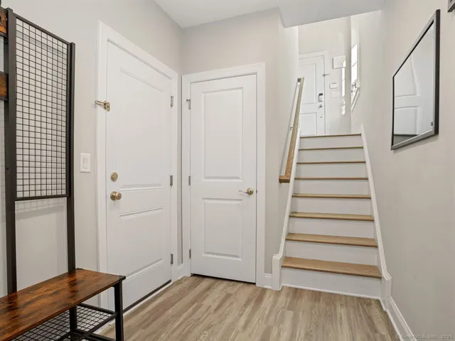 a view of a hallway with wooden floor and entryway