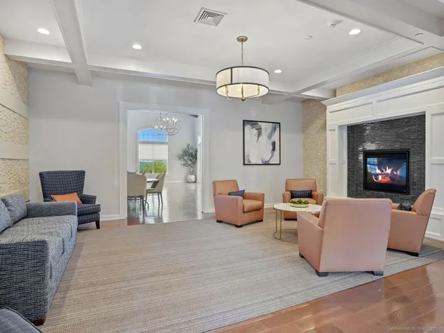 a living room with furniture kitchen view and a chandelier