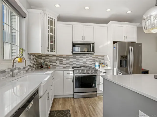 a kitchen with stainless steel appliances granite countertop a sink stove and refrigerator