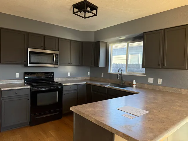 a kitchen with a sink stove and microwave