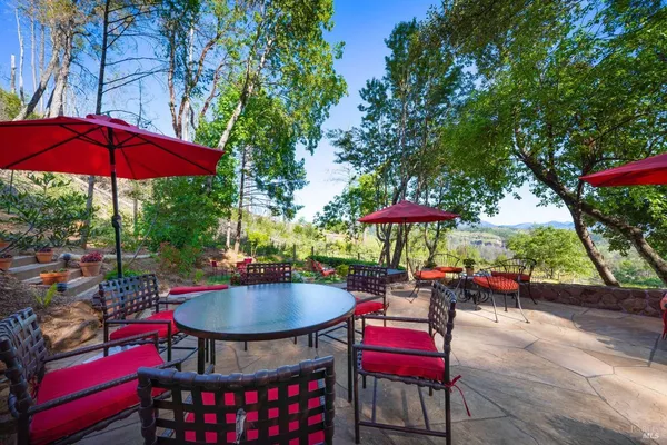 a balcony with wooden floor table and chairs