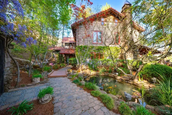 a front view of a house with a yard and potted plants