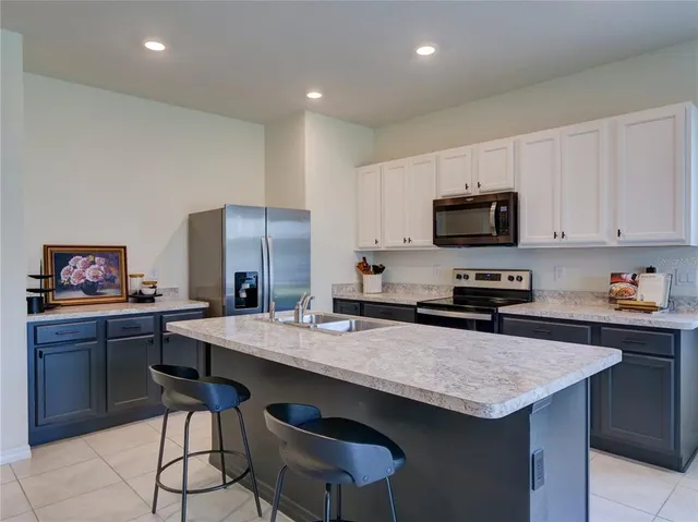 a kitchen with a stove a sink a microwave a dining table and chairs