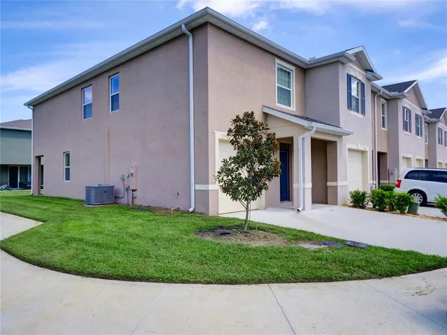 a front view of a house with a garden and plants