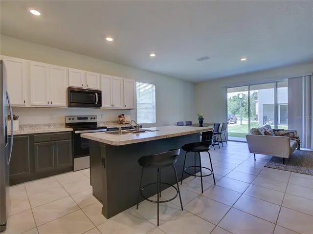 a kitchen with a sink a counter top space appliances and cabinets
