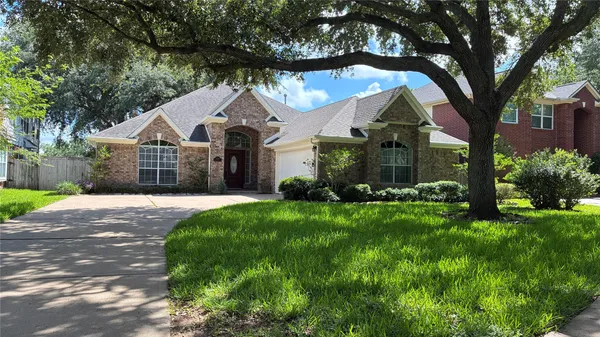 a front view of a house with a garden and trees