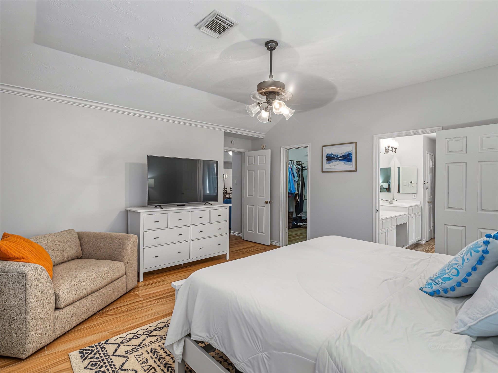 1310 Hidden Canyon Road Katy, TX 77450 - Photo 22 of 40 Spacious Primary bedroom with a cozy sitting area, sleek ceiling fan, walk-in closet and en-suite bathroom.