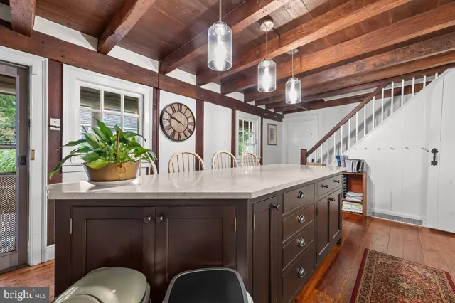 a view of a hallway with entryway and wooden floor