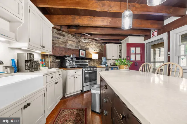 a kitchen with stainless steel appliances granite countertop a sink a stove and cabinets