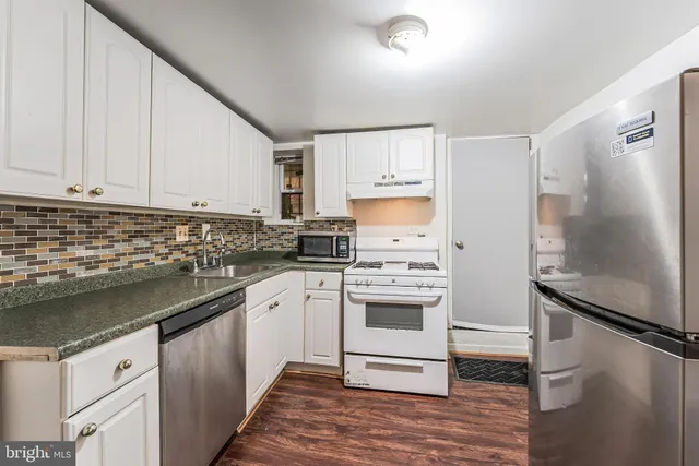 a kitchen with a refrigerator sink and cabinets