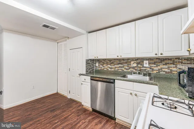 a kitchen with a stove and white cabinets