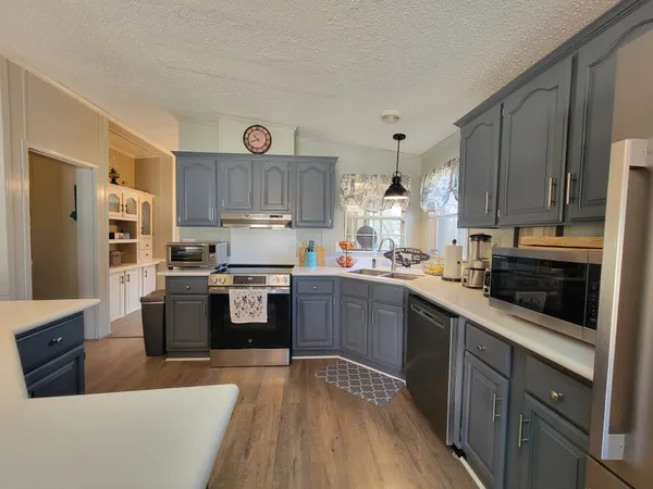 a kitchen with stainless steel appliances granite countertop a dining table and chairs