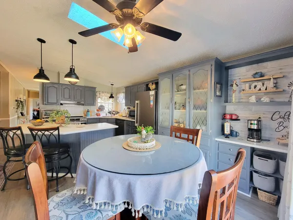 a dining room with furniture a chandelier and wooden floor