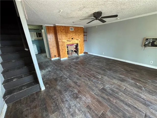 a view of a livingroom with wooden floor and stairs