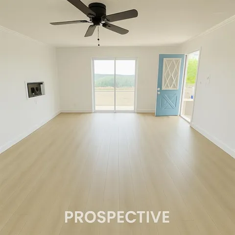 an empty room with windows and chandelier fan