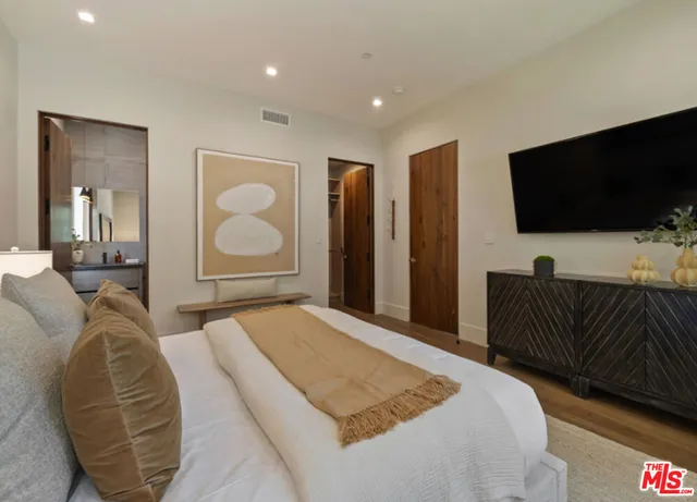 a bedroom with a bed and a flat screen tv