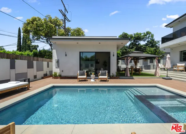 a view of a swimming pool with table and chairs under an umbrella