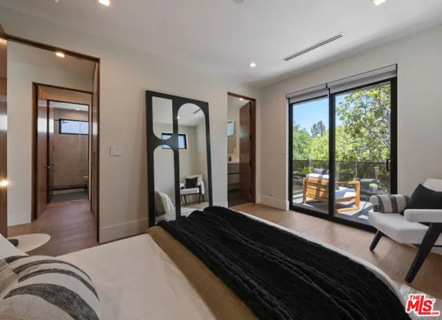 a bedroom with a bed next to a large window