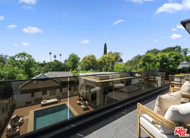 a view of a roof deck with couches and wooden floor