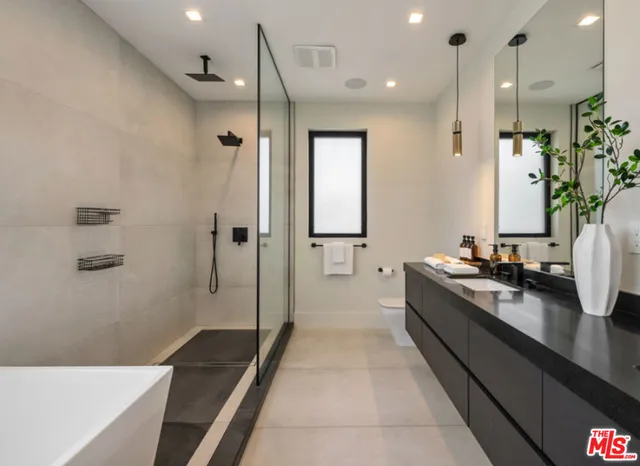 a large bathroom with a double vanity sink a large mirror and shower