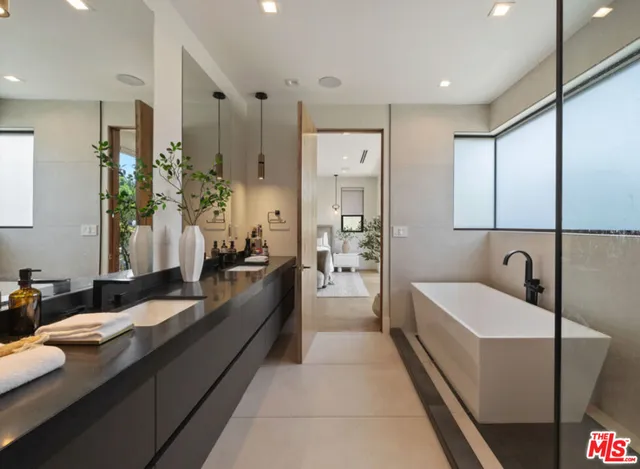 a large bathroom with a double vanity sink a large mirror and a shower