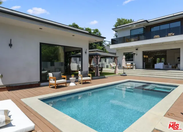 a view of a house with swimming pool and sitting area