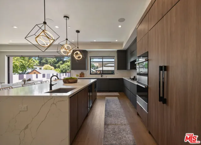 a kitchen with stainless steel appliances granite countertop a sink a stove top oven a counter space and cabinets