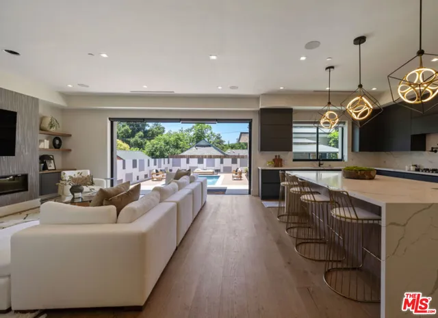 a living room with furniture kitchen and a large window
