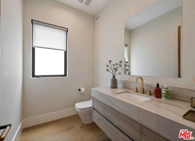 a bathroom with a toilet sink and mirror