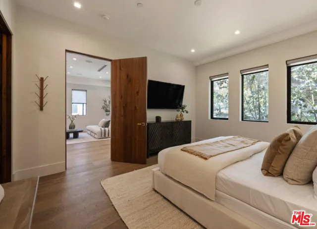 a bedroom with a bed and a flat screen television