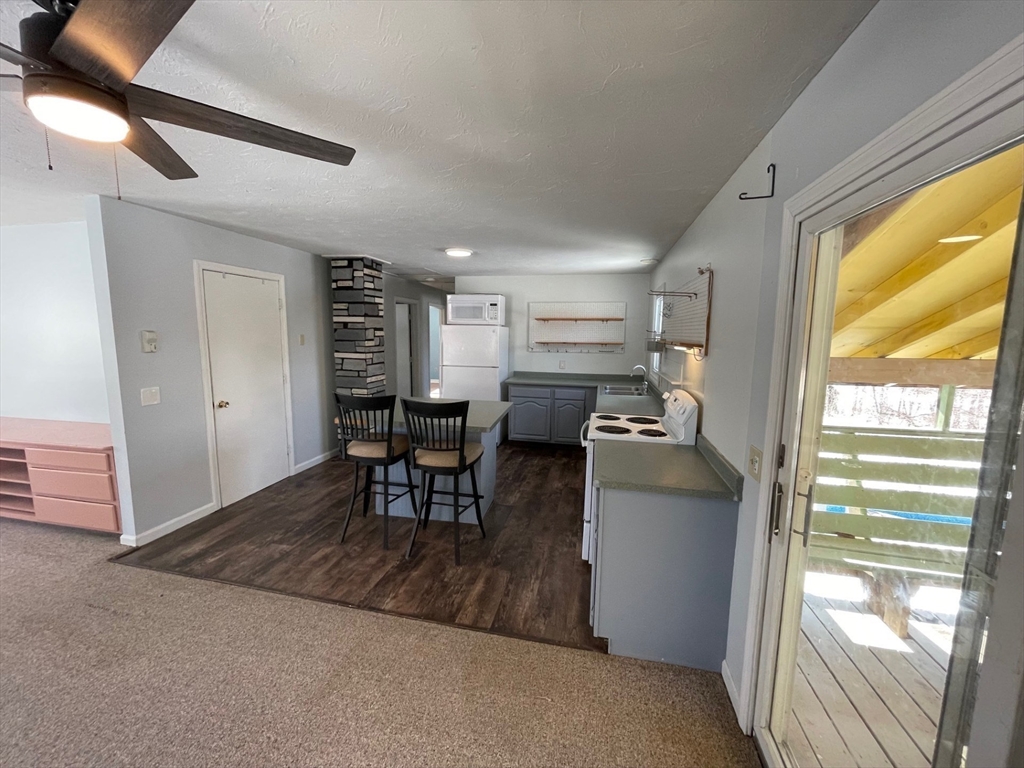 35 Ellis Road Southbridge, MA 01550 - Photo 3 of 29 a kitchen with a table chairs refrigerator and microwave