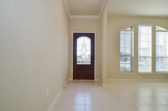 a view of an empty room with window and bathroom