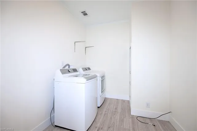 a utility room with wooden floor washer and dryer