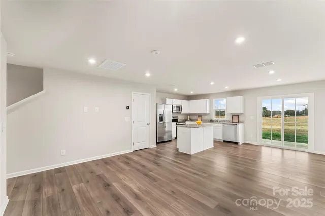 a view of a kitchen with wooden floor and electronic appliances