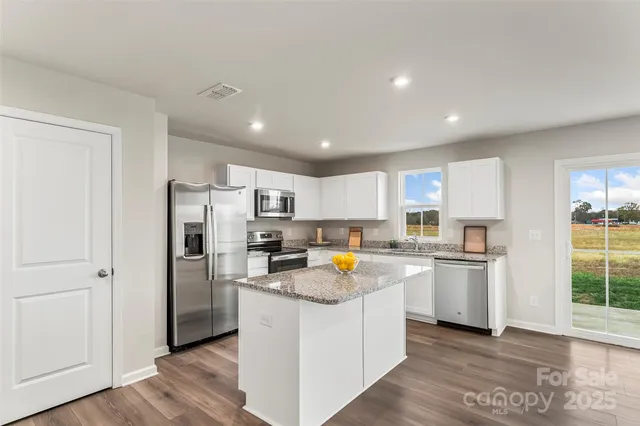 a kitchen with refrigerator a stove a microwave and cabinets