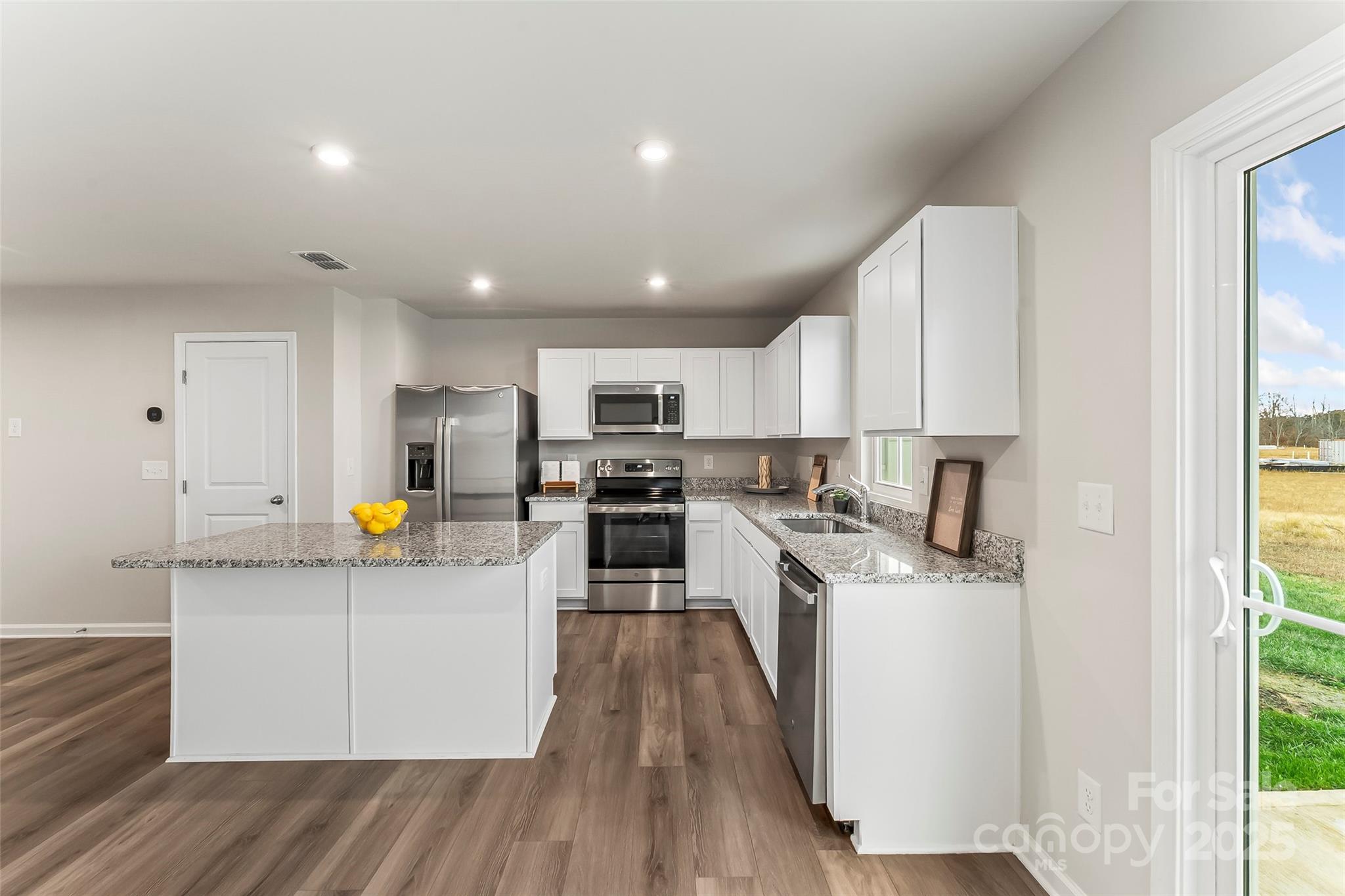 1530 39th Ave Loop Northeast, Unit 3 Hickory, NC 28601 - Photo 6 of 32 a kitchen with stainless steel appliances a refrigerator a sink dishwasher a oven with white cabinets and wooden floor