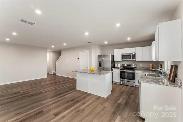 a kitchen with stainless steel appliances a refrigerator and a stove top oven