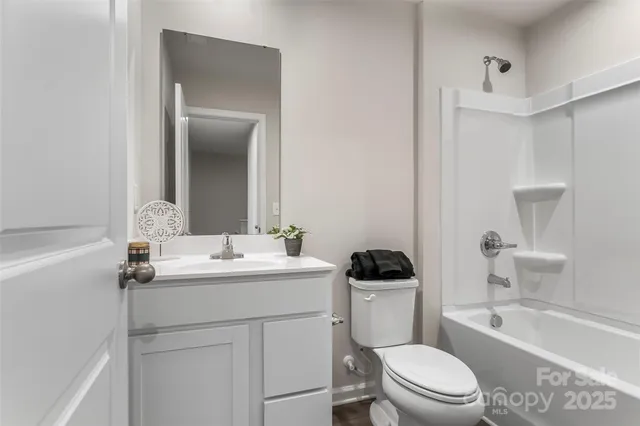 a bathroom with a toilet a sink a tub and mirror