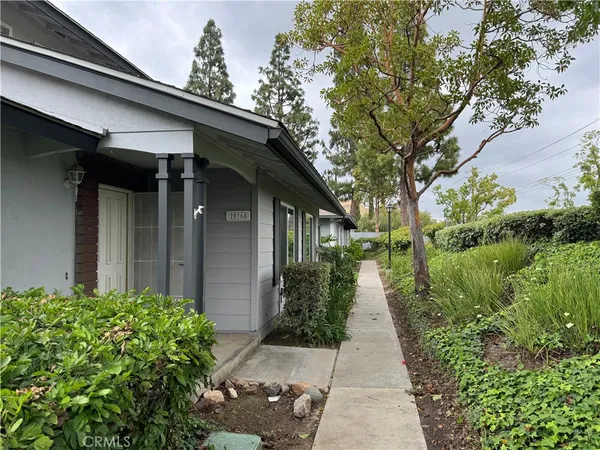 a pathway of a house with potted plants