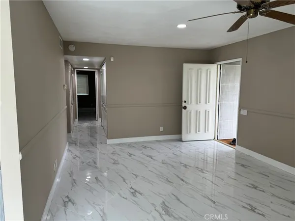 en empty room with wooden floor and ceiling fan