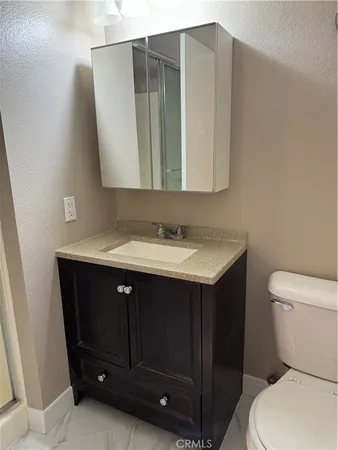 a bathroom with a sink vanity and toilet