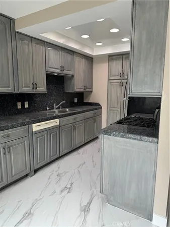 a kitchen with stainless steel appliances granite countertop a sink a stove a refrigerator and cabinets