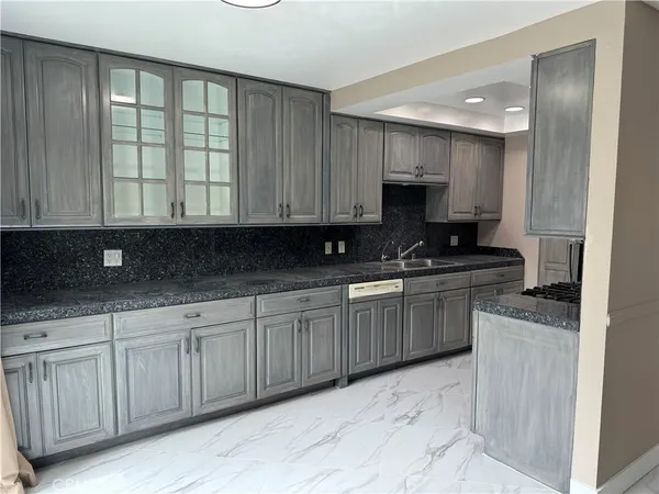 a kitchen with granite countertop a stove a sink and a microwave