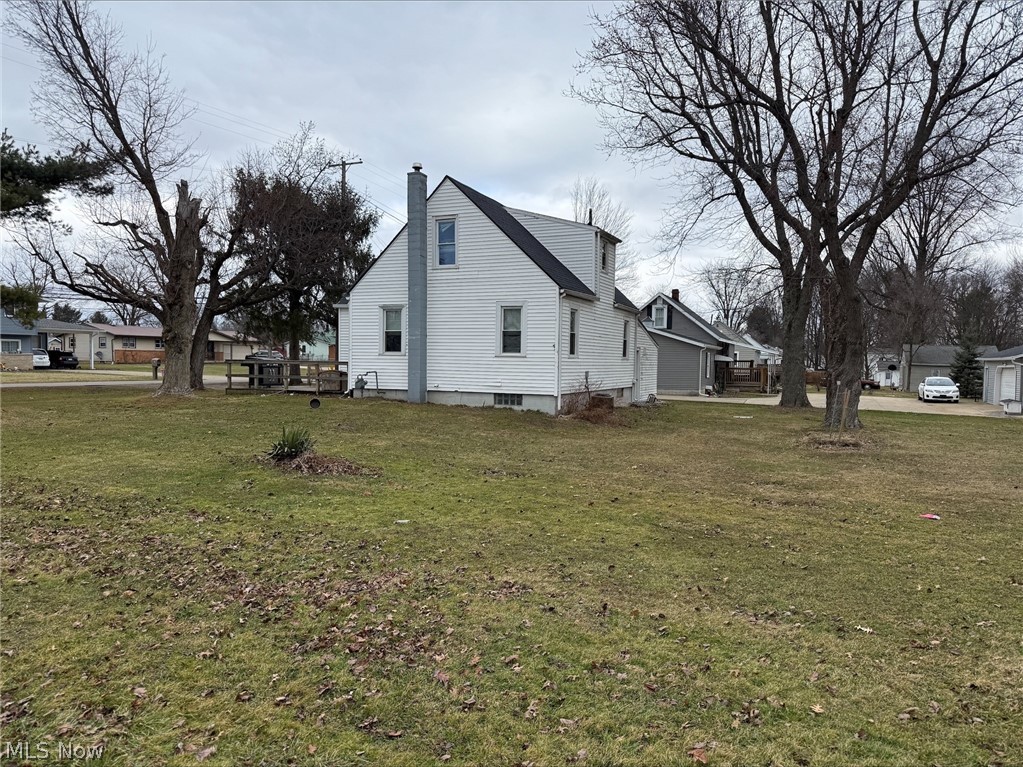 888 Beal Road Mansfield, OH 44905 - Photo 2 of 5 View of property exterior with a chimney, a residential view, and a lawn